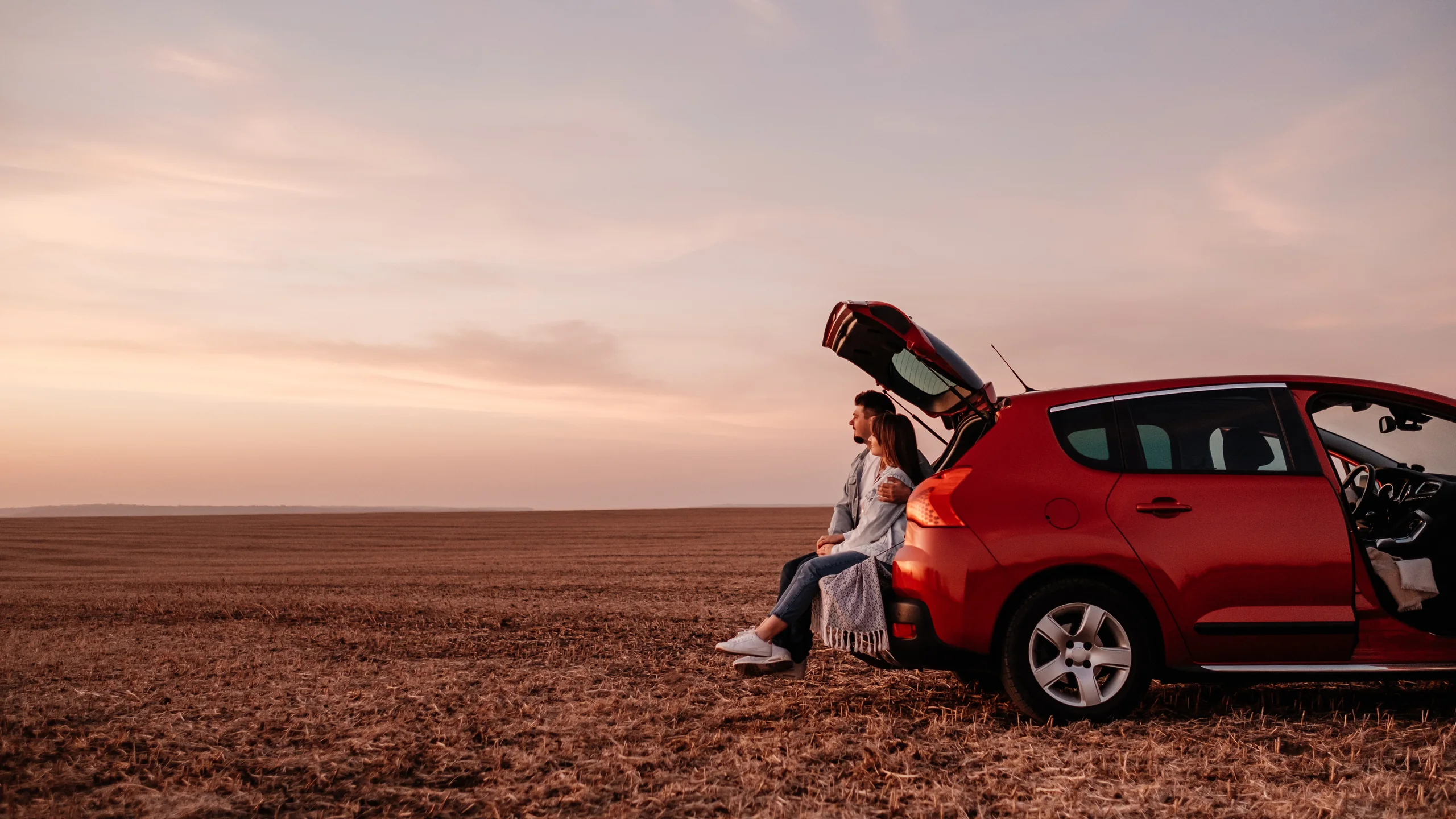 Pareja junto a su automóvil durante un viaje